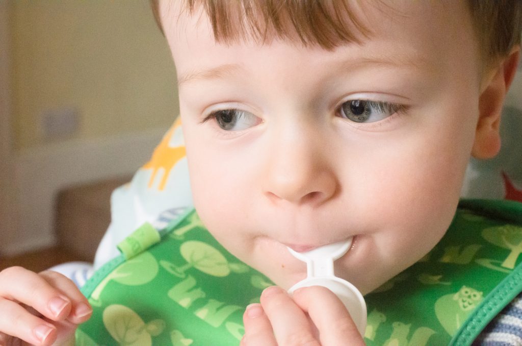 Jonah licking Wellbaby vitamins off the spoon