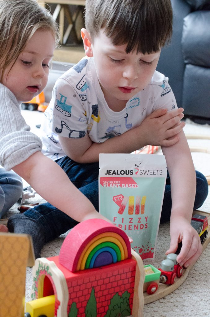 Jonah and Cara playing with toy trains and eating sweets