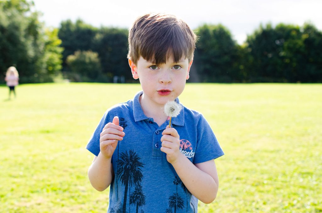 Blowing a dandelion.