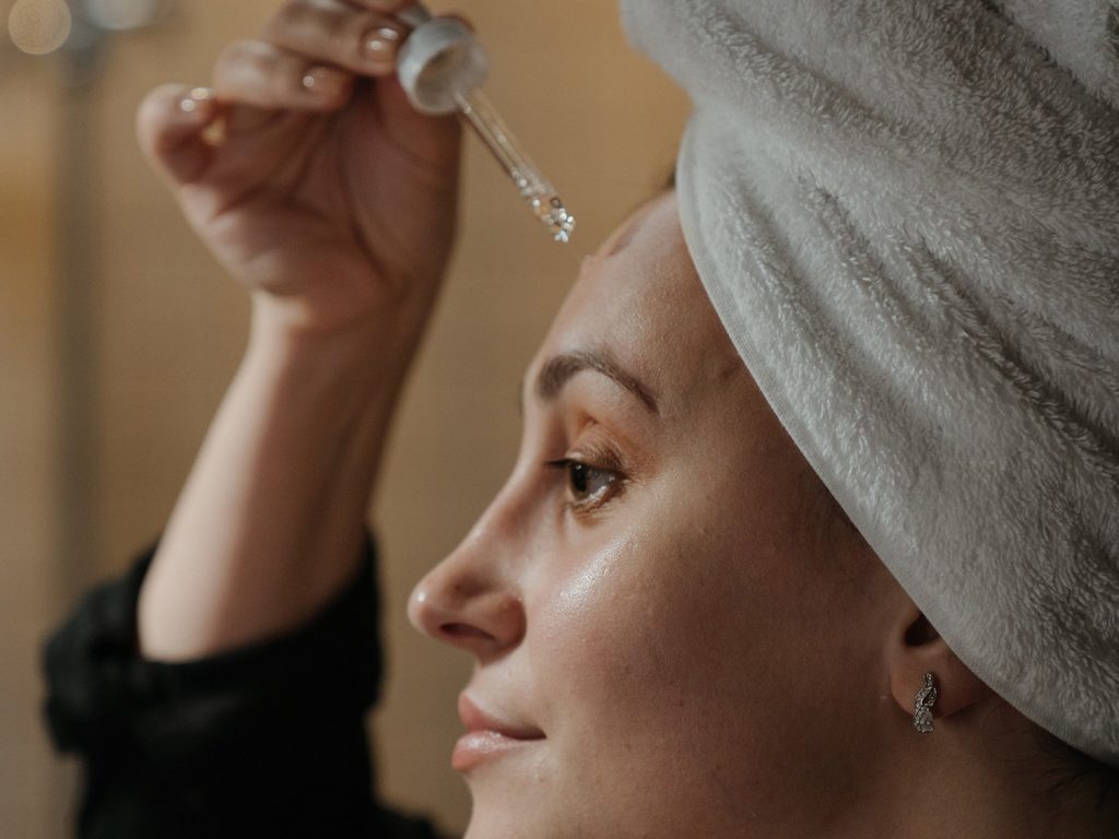 Applying retinol serum.