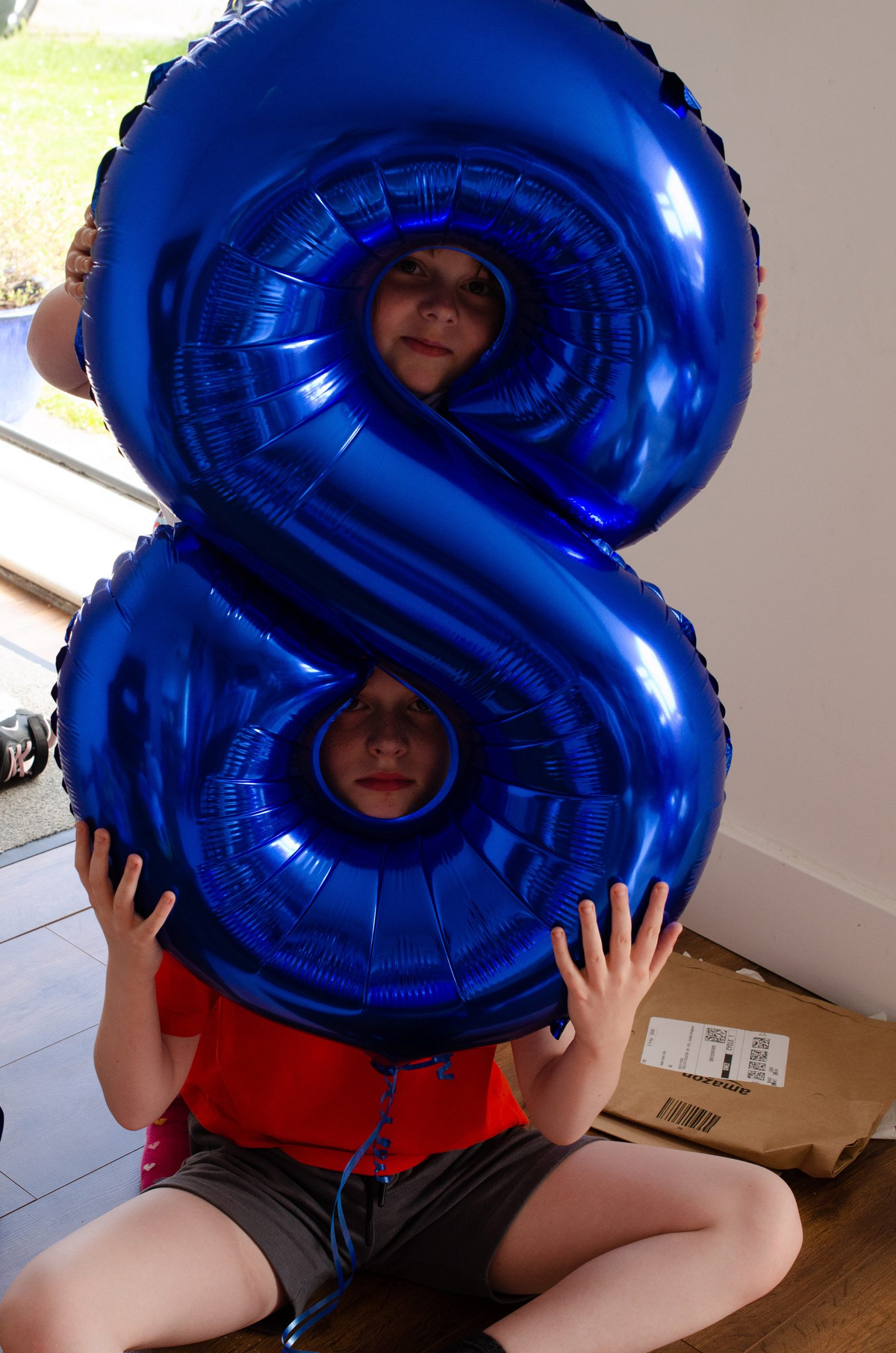 Jonah and Cara with their heads through an 8 balloon